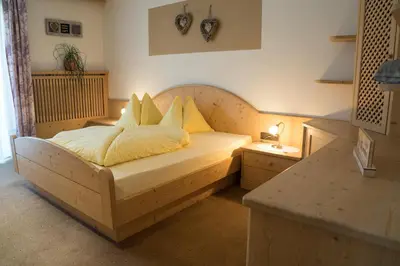 a bedroom with a bed with yellow sheets and pillows at Hilburgerhof in Schenna