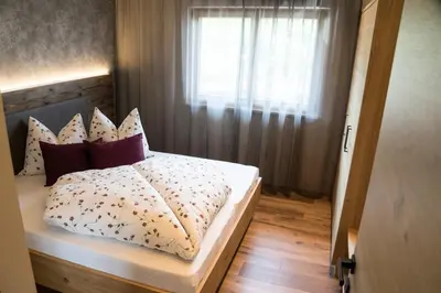 a bedroom with a bed with pillows and a window at Hilburgerhof in Schenna