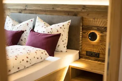 a bed with a bunch of pillows on it at Hilburgerhof in Schenna