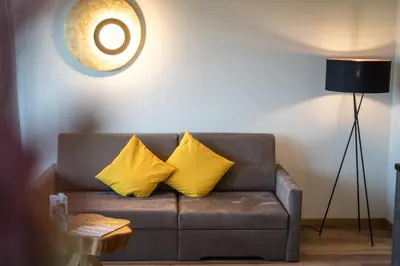 a couch with two yellow pillows in a living room at Hilburgerhof in Schenna
