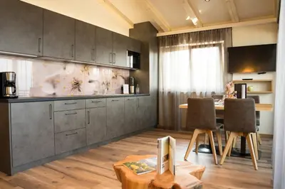 a kitchen with a table and chairs in a room at Hilburgerhof in Schenna
