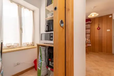 a room with a microwave on a shelf and a window at Casa del Batesta in Moena