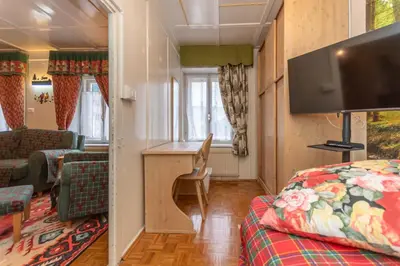 a small room with a bed and a living room at Casa del Batesta in Moena