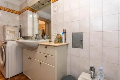 a bathroom with a sink and a washing machine at Casa del Batesta in Moena