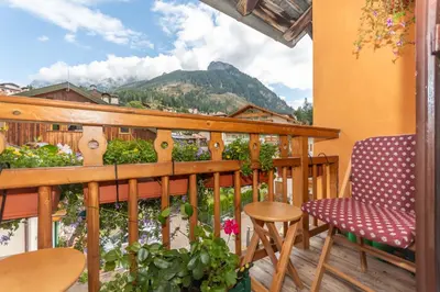 a balcony with chairs and a view of a mountain at Casa del Batesta in Moena