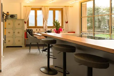 a kitchen with a large wooden table and stools at Puent Seceda-Dolomiti-Val Gardena in Ortisei