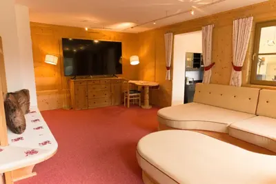 a living room with a couch and a flat screen tv at Puent Seceda-Dolomiti-Val Gardena in Ortisei