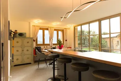 a kitchen with a counter and stools in a room at Puent Seceda-Dolomiti-Val Gardena in Ortisei