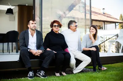 a group of people sitting on the porch of a house at Mirror Houses in Bolzano