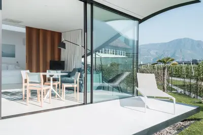 a room with glass walls and a table and chairs at Mirror Houses in Bolzano