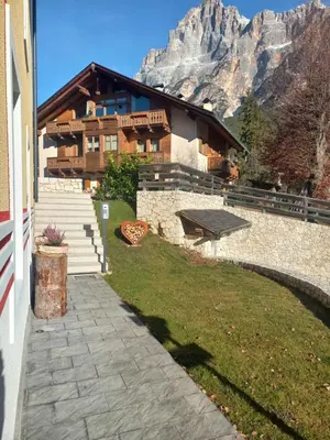 a house with a mountain in the background at Mansarda Vale e Schena con vasca idromassaggio 4 posti letto a Cortina d'Ampezzo in San Vito di Cadore
