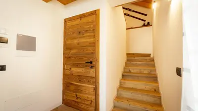 a room with a wooden door and stairs at Mansarda Vale e Schena con vasca idromassaggio 4 posti letto a Cortina d'Ampezzo in San Vito di Cadore