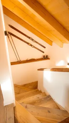 a staircase in a house with wooden floors and wooden ceilings at Mansarda Vale e Schena con vasca idromassaggio 4 posti letto a Cortina d'Ampezzo in San Vito di Cadore