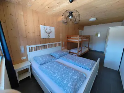 a bedroom with a bed and a wooden wall at Apartment Mair in Valdaora