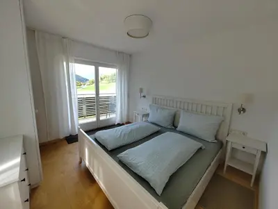 a bed with blue pillows in a room with a window at Apartment Mair in Valdaora