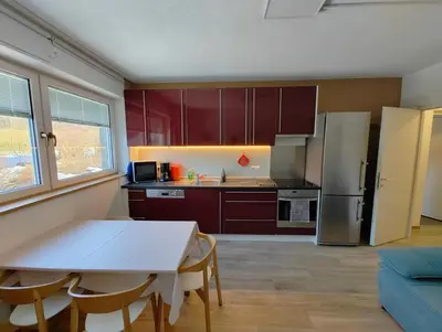 a kitchen with a white table and a refrigerator at Apartment Mair in Valdaora
