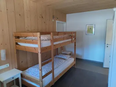 two bunk beds in a room with wooden walls at Apartment Mair in Valdaora
