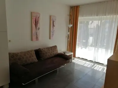 a living room with a couch and a large window at Apartment Mair in Valdaora