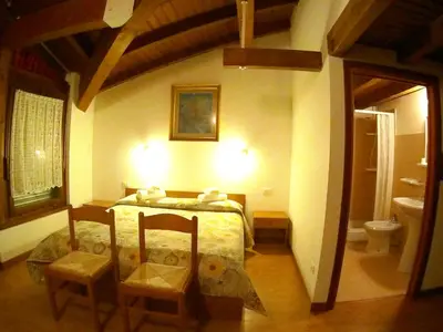 a bedroom with a bed and two chairs in it at Hotel Salgetti in Mezzano