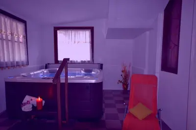 a bathroom with a tub and a sink and a red chair at Hotel Salgetti in Mezzano