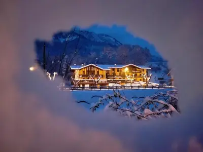 a house in the snow with lights at Hotel Salgetti in Mezzano
