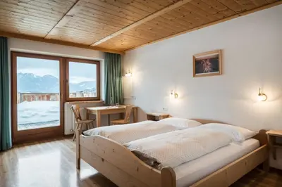 a bedroom with a large bed and a large window at Hotel Ciurnadú in La Valle