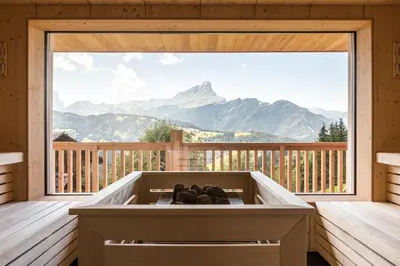 a hot tub on a deck with a view of mountains at Hotel Ciurnadú in La Valle