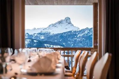a table with chairs and a view of a mountain at Hotel Ciurnadú in La Valle