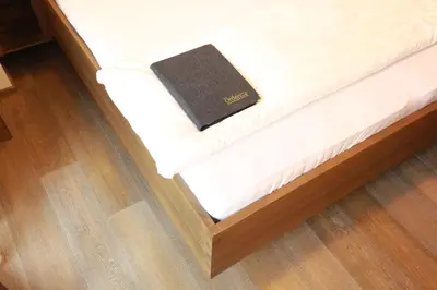 a book sitting on the bottom of a bed at Örtlerhof in Tirolo