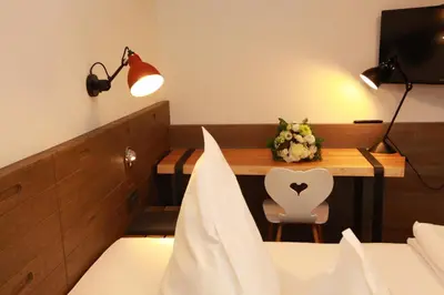 a hotel room with a table with a flower arrangement on it at Örtlerhof in Tirolo