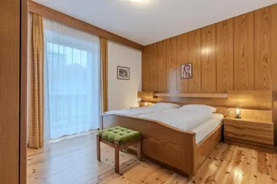 a bedroom with a large bed and a large window at Haus Vieider in Collepietra
