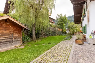 a garden with a brick walkway next to a building at Haus Vieider in Collepietra