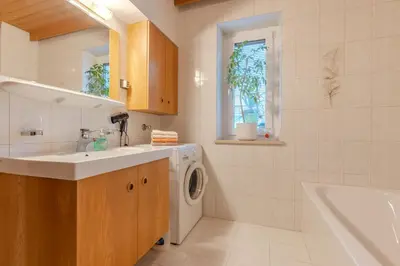 a bathroom with a sink and a washing machine at Haus Vieider in Collepietra