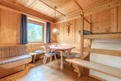 a log cabin with a table and a bunk bed at Haus Vieider in Collepietra