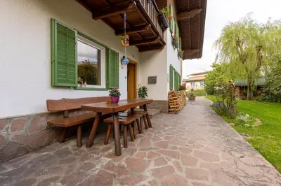 a patio with a wooden table and benches at Haus Vieider in Collepietra