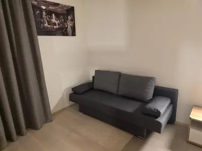 a black couch in a room with a curtain at V91 Young People Citymountain in Brunico
