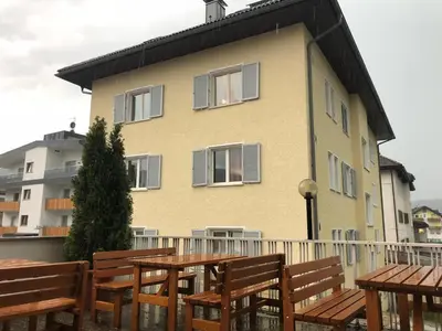a building with wooden tables and benches in front of it at V91 Young People Citymountain in Brunico