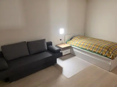 a small room with a couch and a bed at V91 Young People Citymountain in Brunico