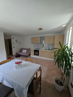 a living room with a table and a kitchen at Comodità in centro a Tesero in Tesero