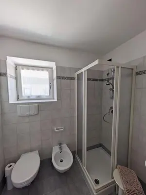 a bathroom with a shower and a toilet and a sink at Comodità in centro a Tesero in Tesero