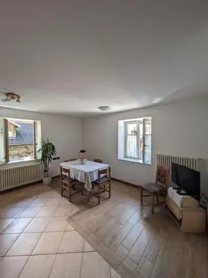 a living room with a table and a couch at Comodità in centro a Tesero in Tesero