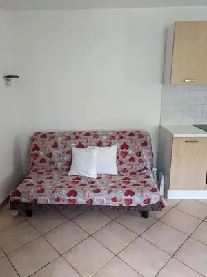 a red couch with two pillows in a room at Comodità in centro a Tesero in Tesero