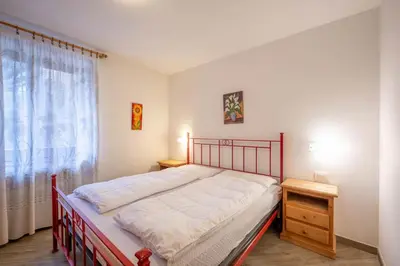 a bedroom with a large bed and a window at Cesa de Piè in Canazei