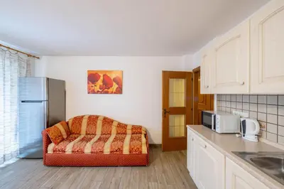 a kitchen with a couch in the corner of a kitchen at Cesa de Piè in Canazei