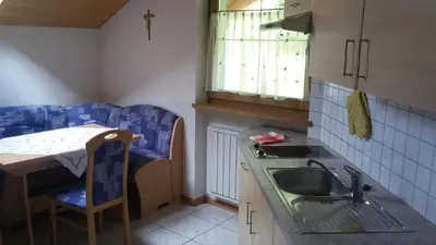 a kitchen with a sink and a table with blue chairs at Roanerhof in San Genesio Atesino