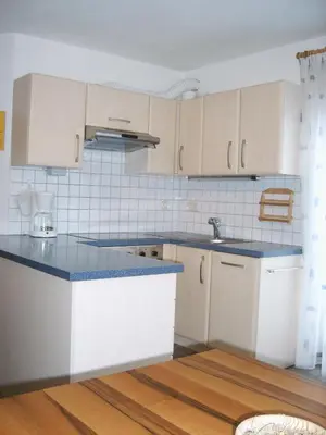 a kitchen with white cabinets and blue counter tops at Roanerhof in San Genesio Atesino
