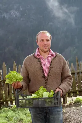 a man is holding a basket of lettuce at Roanerhof in San Genesio Atesino