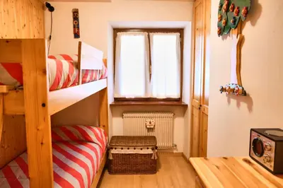a small room with a bunk bed and a window at Villa Antermont in Canazei