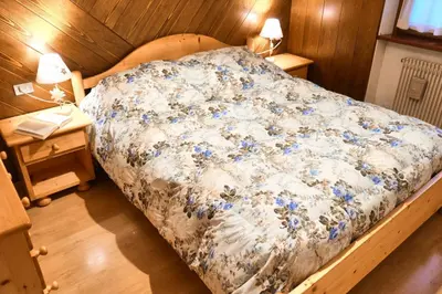 a bedroom with a bed with blue flowers on it at Villa Antermont in Canazei