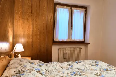 a bedroom with a bed and a window at Villa Antermont in Canazei